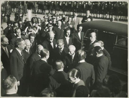 Einaudi giunge a Montecitorio per la cerimonia del giuramento e saluta alcune personalità; accanto a lui, Gronchi