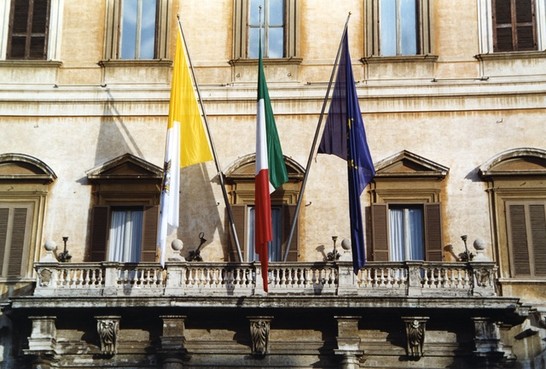 La Bandiera dello Stato della Città del Vaticano esposta accanto alle Bandiere italiana ed europea nella facciata di Palazzo Montecitorio