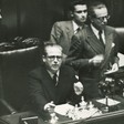 Gronchi seduto nello scranno di presidente della Camera; in piedi accanto a lui Martino